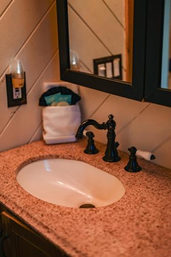 a bathroom counter with a sink and a mirror at The Robins Nest with hot tub in Pigeon Forge