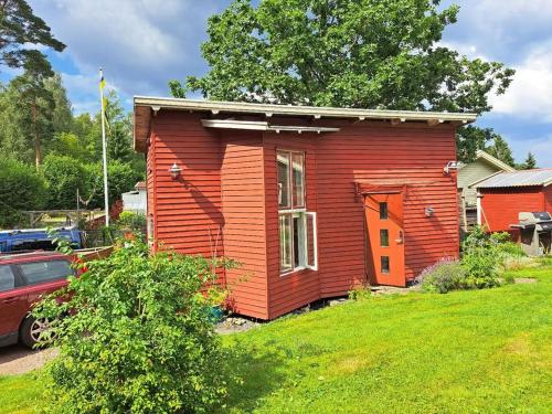 a small red house in a yard with a car at Nature- & lakeside accommodation in Lerum