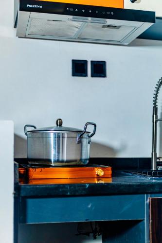 a pot on top of a stove in a kitchen at Banora Apartments Gwarinpa in Gwarinpa