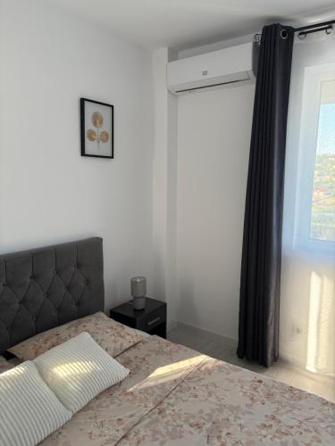 a bedroom with a bed with a black curtain and a window at Lake View Apartment Iasi in Valea Lupului