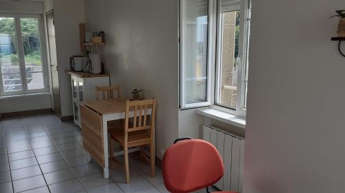 a small kitchen with a desk and a red chair at Le Studio du Nevet in Douarnenez