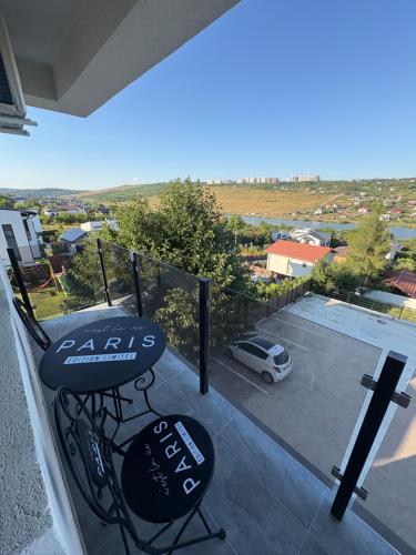 a balcony with two chairs and a view of a parking lot at Lake View Apartment Iasi in Valea Lupului