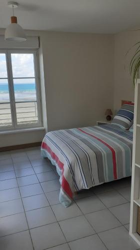 a bedroom with a bed with a view of the ocean at Le Studio du Nevet in Douarnenez