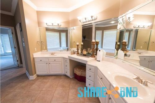 a bathroom with two sinks and a large mirror at Elegant Lakefront Home W Covered Patio in Little Rock