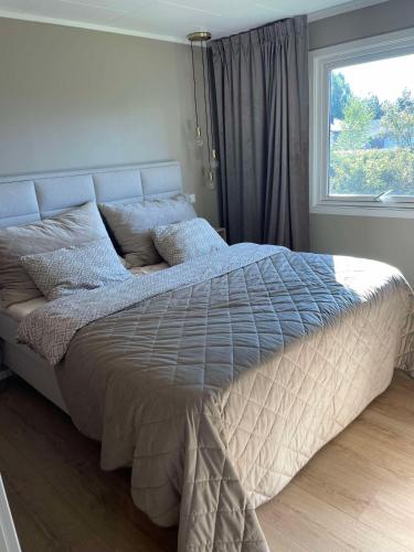 a large bed in a bedroom with a window at Modern 3 bedroom villa 10min from Oslo Airport Gardermoen in Jessheim