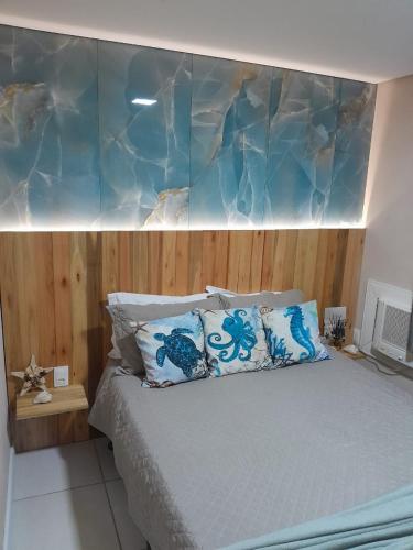 a bedroom with a bed with a wooden head board at Apartamento térreo climatizado próximo a praia in Itapema