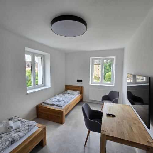 a living room with two beds and a table at Ela Apartments Farní in Skalná