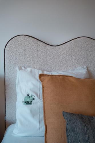 a bed with a pillow with a sign on it at OceanGreen Matosinhos - EcoHost in Matosinhos