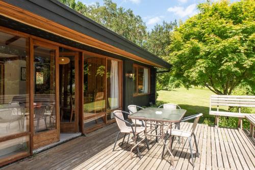a wooden deck with a table and chairs on it at Hotel y Cabañas El Parque in Villarrica