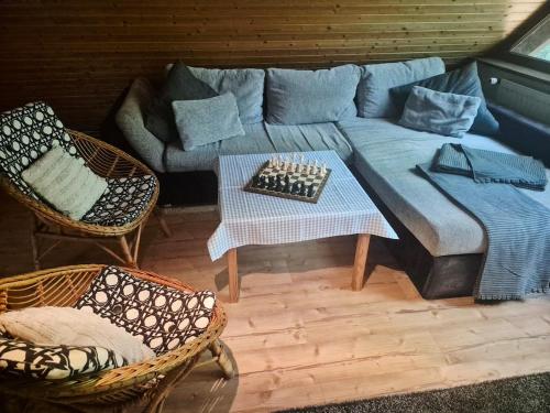 a living room with a couch and two chairs at Idyllisch & ruhig - gemütliches Ferienhaus im Wald Hunde willkommen, in Hatten, nahe Oldenburg in Hatten