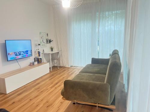 a living room with a couch and a flat screen tv at Dimoro Family Suites - Designed for your comfort in Essen