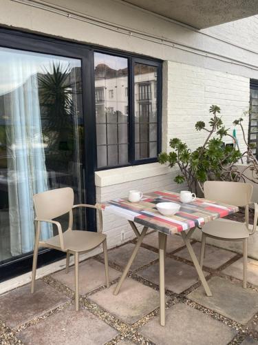 a table and two chairs on a patio at Heart of Hout Bay, Apartment in Cape Town