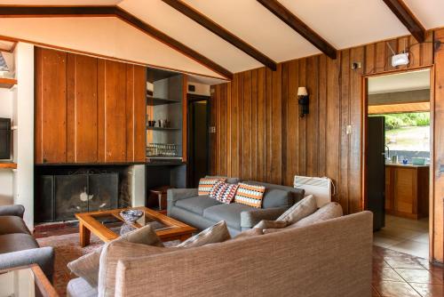 a living room with a couch and a fireplace at Hotel y Cabañas El Parque in Villarrica