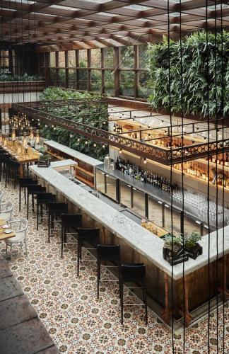 a restaurant with long tables and chairs and plants at Four Seasons Hotel Casa Medina Bogota in Bogotá