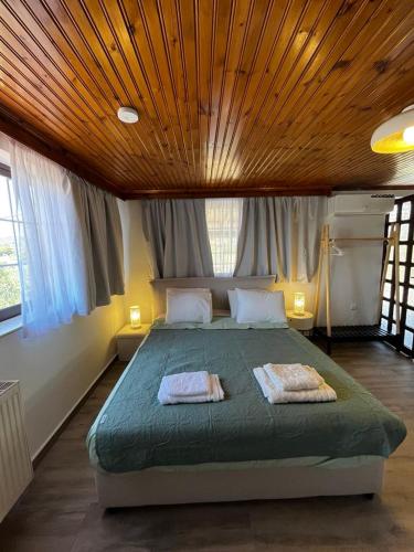 a bedroom with a large bed with two towels on it at Blue Olive House & Studio in Artemida