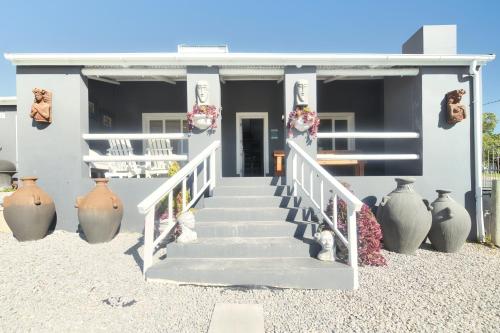 a house with a staircase with vases in front of it at Hugo Haven in Bredasdorp