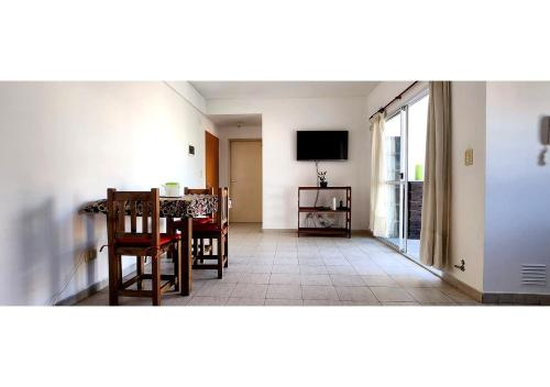 a living room with a dining room table and a television at Depto con balcón y mucha luz en CABA in Buenos Aires