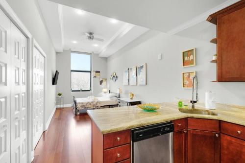 a kitchen with a sink and a living room at XL Studio - Premier Studio with Gym Access in Philadelphia