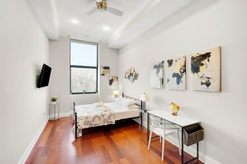 a white room with a bed and a table at XL Studio - Premier Studio with Gym Access in Philadelphia
