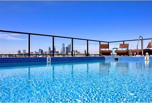 a large swimming pool with a city skyline in the background at XL Studio - Premier Studio with Gym Access in Philadelphia