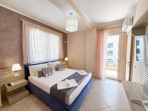 a bedroom with a bed and a large window at Bel Ami Suita Hotel in Vlorë