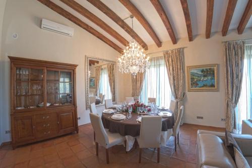 a dining room with a table and chairs and a chandelier at Mallorca Villa 1463: Relax in Your Private Oasis in Deia