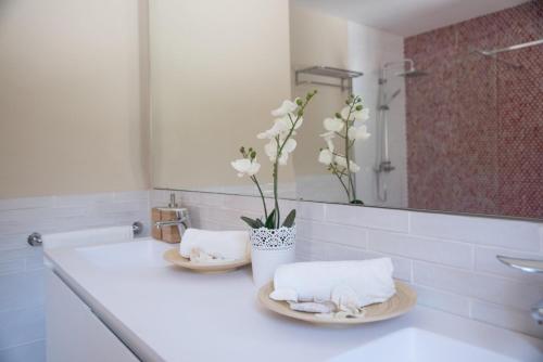 a bathroom with two towels and a vase with flowers at Mallorca Villa 1463: Relax in Your Private Oasis in Deia
