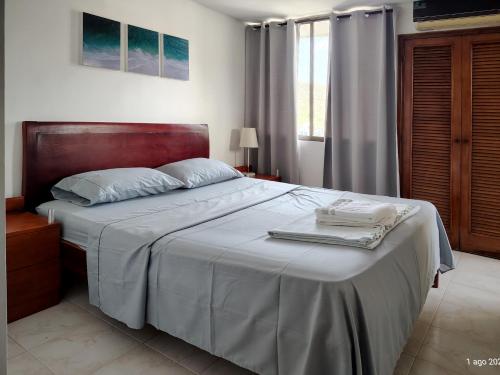 a bedroom with a large bed with a wooden headboard at Apartamento frente al mar in Rodadero