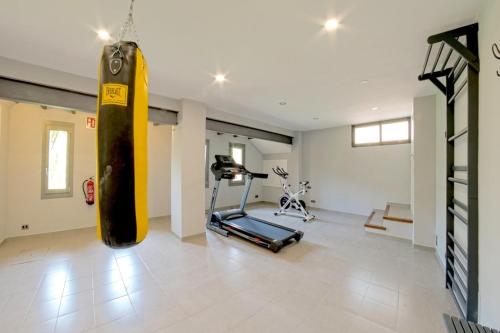 a room with a gym with a punching bag and a treadmill at Mallorca Villa 1463: Relax in Your Private Oasis in Deia
