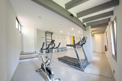 a gym with a treadmill and a bike in a room at Mallorca Villa 1463: Relax in Your Private Oasis in Deia