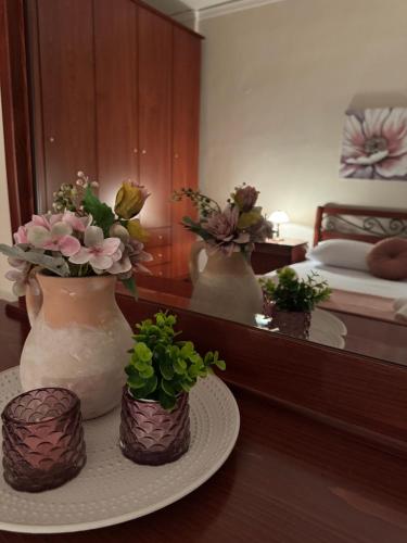 a room with three vases with flowers on a table at Lina Home in Drama