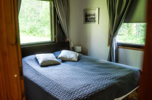 a bedroom with a bed with two pillows on it at Villa Christmas Star Private Sauna By Lapland Host in Rovaniemi