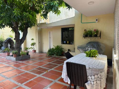 a patio with a table and some potted plants at Our House in Santa Marta