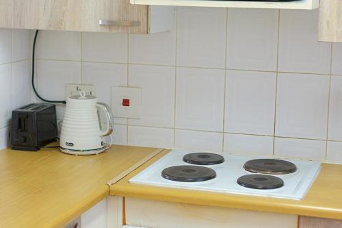 a white stove top in a kitchen with a blender at Chic 2BR Apartment in Roodepoort in Roodepoort