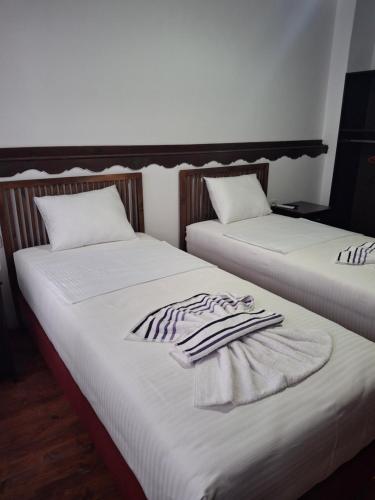 two beds sitting next to each other with towels on them at MiziriGuestHouse in Gjirokastër