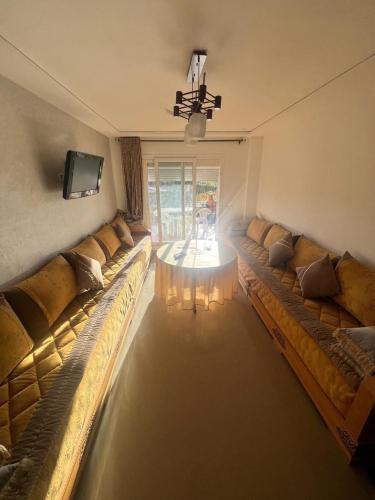 a living room with two large couches and a television at Apparemment saidia ap13 in Saidia 