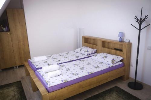 a bedroom with a wooden bed with towels on it at Pensiunea Casa Lola in Bontida