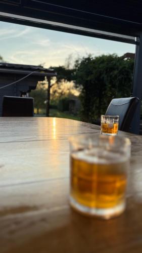 a glass of beer sitting on top of a wooden table at Tubize in Tubize