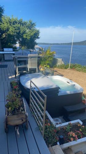 a boat sitting on a deck next to some plants at Beachbreeze Panoramic Oceanview 4BR 3BA Romantic Sunrise & Celestial Views in Mill Bay