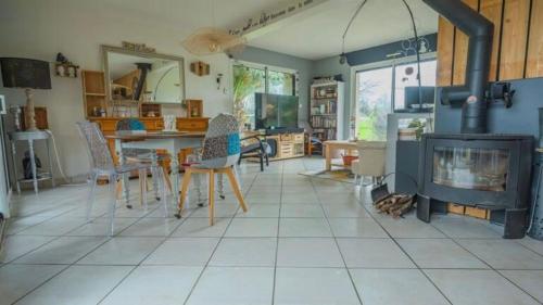 - un salon avec une cheminée, une table et des chaises dans l'établissement lesmainsdelange, à Concarneau