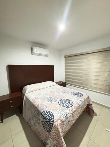 a bedroom with a bed and a window at Almarena Residencial in Mazatlán
