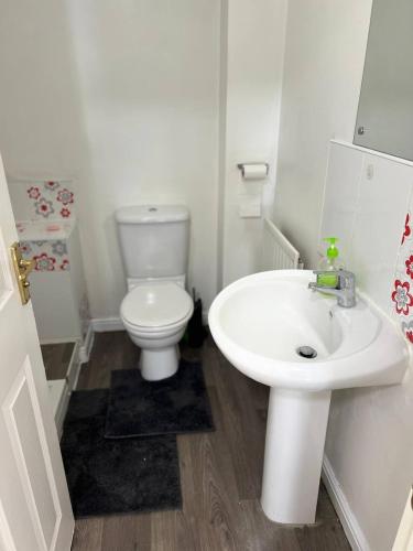 a white bathroom with a toilet and a sink at Etruria House - Near Water World, Festival Park and Bet365 in Stoke on Trent