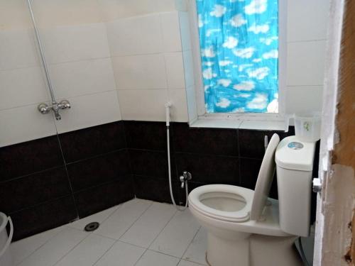 a bathroom with a toilet and a window at Junction Resort 