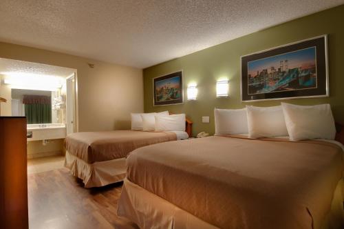 a hotel room with two beds and a window at Vagabond Inn Bakersfield South in Bakersfield