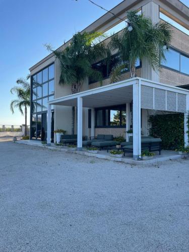 a building with couches and palm trees in front of it at Terra di Negroamaro in Leverano