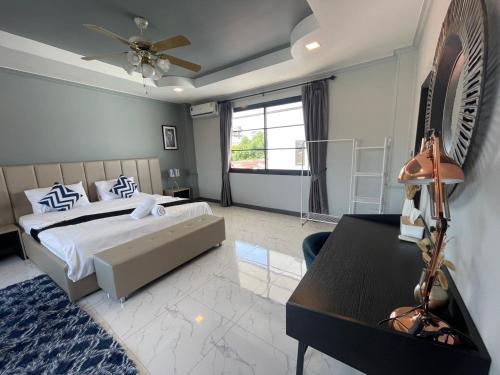 1 dormitorio con 1 cama, escritorio y ventilador en BoomVilla 2, en Pattaya South