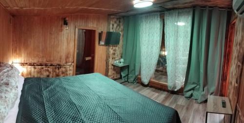a bedroom with a bed with a green comforter at Oasis rural in Benidorm in Benidorm
