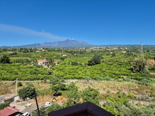 Una vista de un pueblo con montañas al fondo. en Casa Egle - Between Etna and the sea, en Giarre