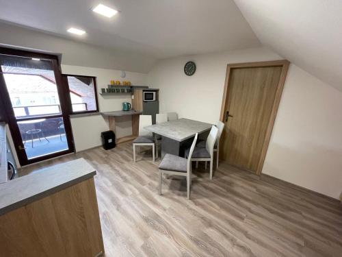 a room with a table and chairs and a kitchen at Apartmány PEKÁR in Silica