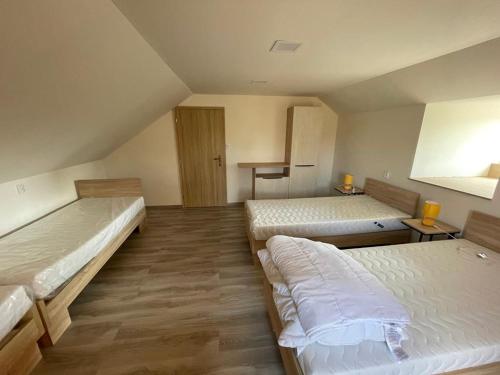 a room with two beds in a room with wooden floors at Apartmány PEKÁR in Silica